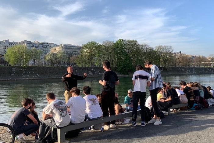 Young people gathered Wednesday by the Seine River in Paris, largely without masks and without social distancing. French President Emmanuel Macron has ordered the country into a third lockdown because of the continued spread of COVID-19.