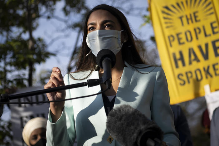 Rep. Alexandria Ocasio-Cortez, D-N.Y., speaks with other Democratic members of Congress outside of the Democratic National Headquarters in November, urging then-President-elect Biden to address the climate crisis.