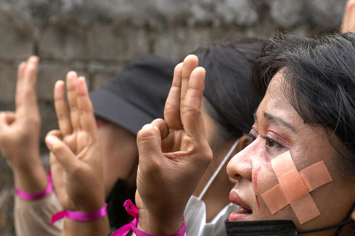 Protesters, wearing red makeup to simulate tears of blood, making the three-finger salute during a demonstration against the military coup in Hlaing Township, Yangon, Myanmar, on Thursday in a photo taken from a screenshot from AFPTV video.