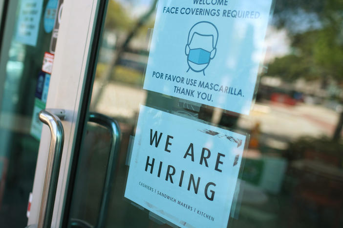 A store in Miami displays a "We are hiring" sign on March 5. U.S. employers added 916,000 jobs in March, the biggest number since August, amid an improving pandemic outlook and trillions of dollars in stimulus passed by Congress.
