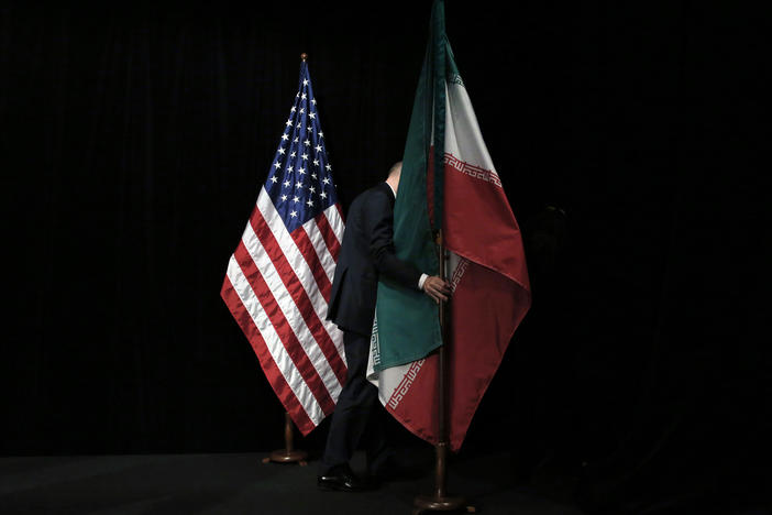 A staff person removes the Iranian flag from the stage after a group picture with representatives of the United States, Iran, China, Russia, Britain, Germany, France and the European Union during the Iran nuclear talks in July 2015 in Vienna.