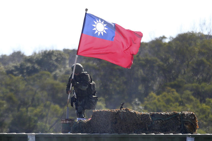A soldier holds a Taiwanese flag during a military exercise in Hsinchu County, northern Taiwan, in January. Taiwanese troops using tanks, mortars and small arms staged a drill aimed at repelling an attack from China.