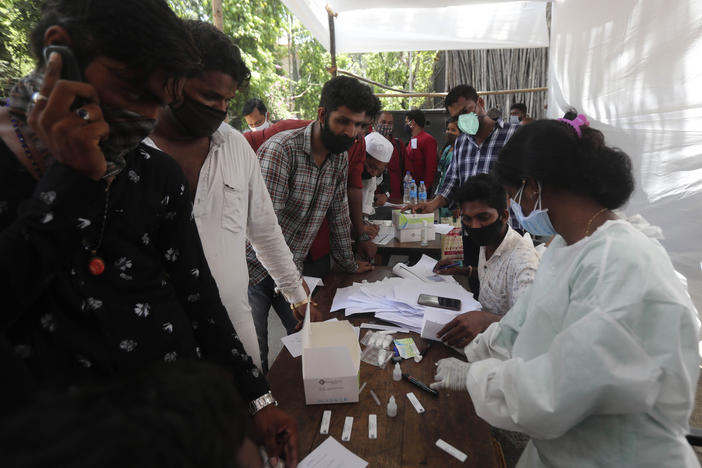 People wait for coronavirus tests outside a court in Mumbai on Monday as India reported its biggest single-day spike in confirmed coronavirus cases since the pandemic began.