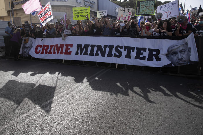 Protesters gather outside the District Court in Jerusalem where Prime Minister Benjamin Netanyahu was attending his corruption trial Monday.