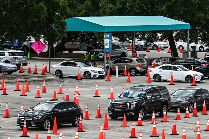 People wait in their vehicles to get vaccinated last week at a drive-through site at Hard Rock Stadium in Miami Gardens, Fla. President Biden announced an April 19 deadline for all states to open eligibility to individuals ages 18 and up.