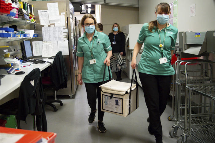 On Wednesday, pharmacists at the West Wales General Hospital in Carmarthen, Wales, transport a cool box containing the first batch of Moderna vaccines being distributed in Britain.