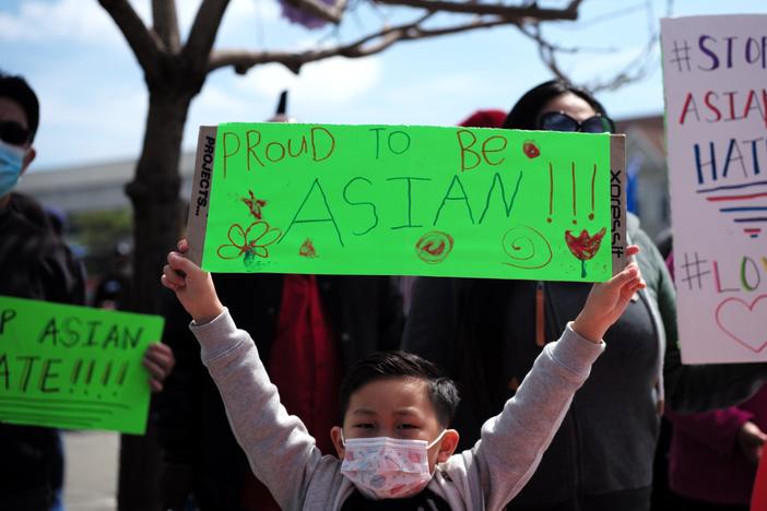 A boy holding a sign takes part in a Stop Asian Hate rally in Oakland, Calif.