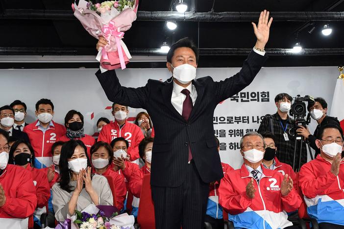 Oh Se-hoon (center), the mayoral candidate of the main opposition People Power Party, holds flowers as he celebrates with party members after exit polls showed he would win.