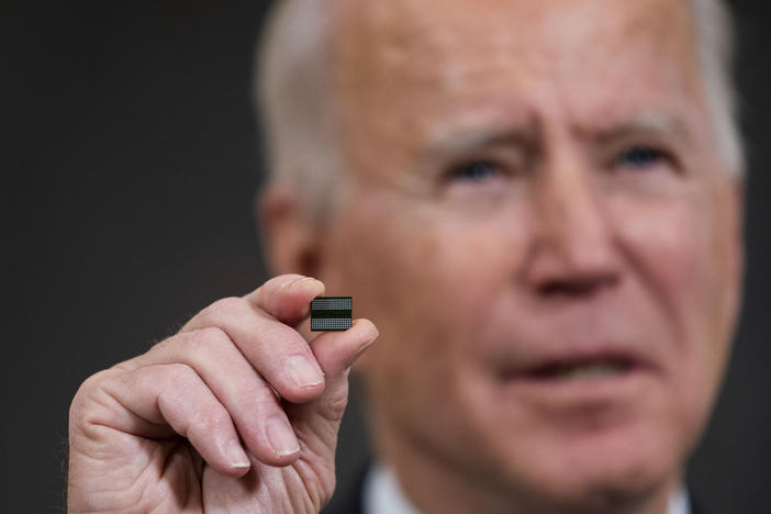 President Biden holds a semiconductor during remarks before signing an executive order on the economy at the White House on Feb. 24. On Monday, senior members of his team met with leaders across various industries to discuss a shortage of semiconductors.