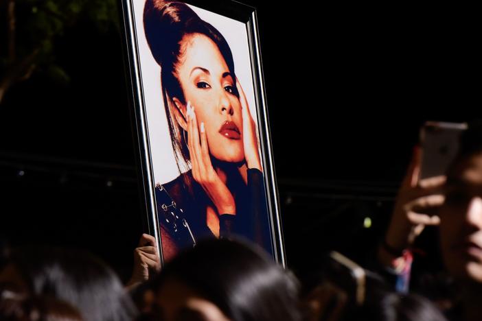 Fans with a photo of Selena during a ceremony honoring her in 2017. Over the decades since her death, Selena's legacy has become even more profound than writer Deborah Paredez ever anticipated.