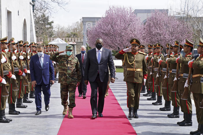 U.S. Defense Secretary Lloyd Austin, center, walks on the red carpet with Afghan officials as they review an honor guard at the presidential palace in Kabul, Afghanistan, on March 21. President Biden said the U.S. will withdraw all remaining troops from the country by Sept. 11, ending the U.S. involvement in the America's longest-ever war.