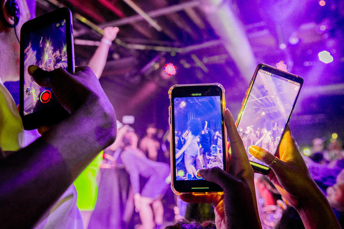 You can do a lot of things with minimal risk after being vaccinated. Although our public health expert says that maybe it's not quite time for a rave or other tightly packed events. Above: Fans take photographs of Megan Thee Stallion at a London show in 2019.