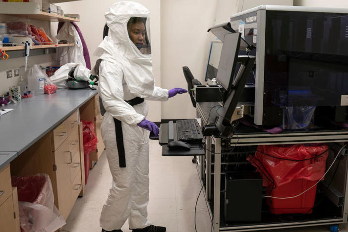 Lab assistant Tammy Brown dons personal protective equipment in a lab at the University of Maryland School of Medicine in Baltimore. She works on preparing positive coronavirus tests for sequencing to discern variants rapidly spreading throughout the country.