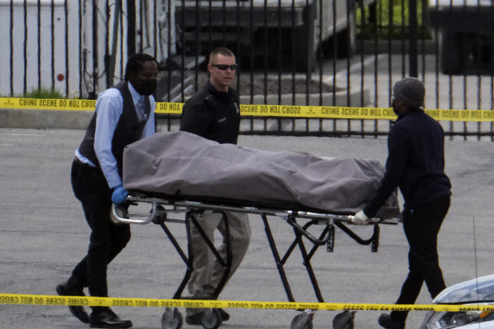Officials recover a body Friday at the site of a mass shooting at a FedEx facility in Indianapolis.