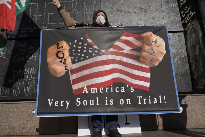 A protester stands across the street from the Hennepin County Government Center on Tuesday, where former Minneapolis police officer Derek Chauvin stands trial for the death of George Floyd.