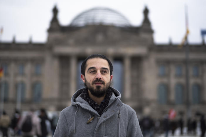 Tareq Alaows stands in front of the Bundestag, Germany's parliament, in Berlin. Alaows came to Germany as an asylum-seeker from Syria in 2015. He launched a campaign to run in Germany's federal election in September for the Green Party but recently withdrew his candidacy.