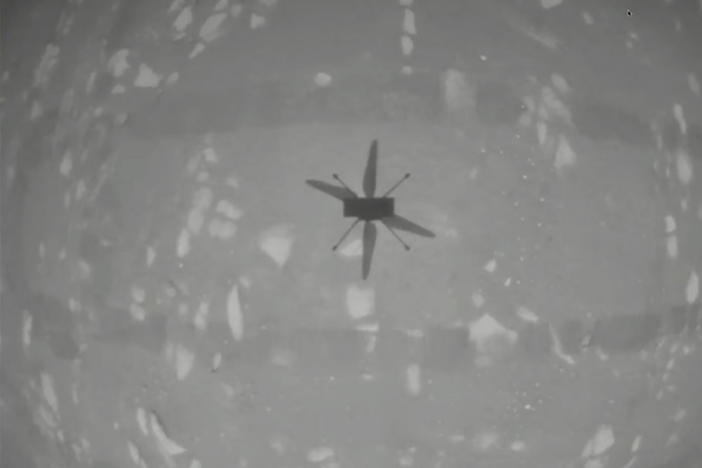 NASA's experimental Mars helicopter Ingenuity hovers above the surface of Mars on Monday.
