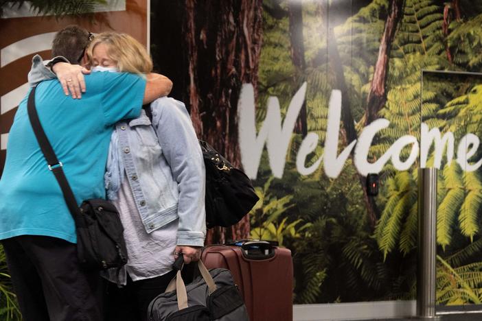 Families are reunited as travelers arrive on the first flight from Sydney in Wellington on Monday after Australia and New Zealand opened a trans-Tasman quarantine-free travel bubble.