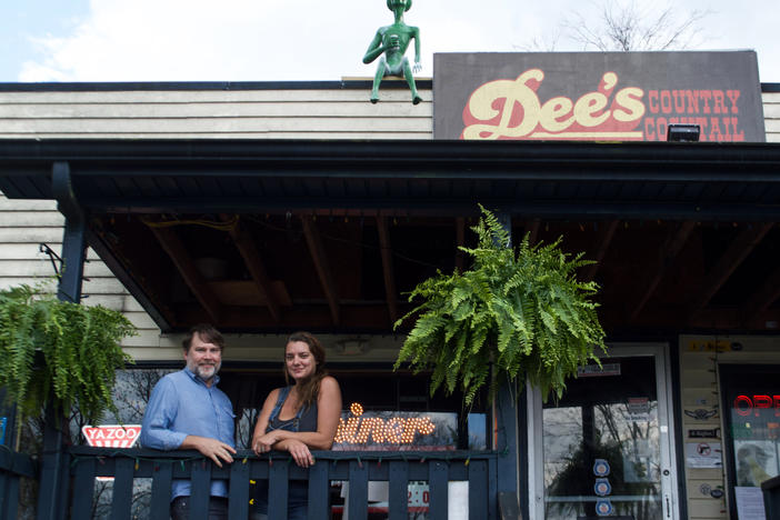 Daniel Walker and Amy Dee Richardson, owners of Dee's Country Cocktail Lounge pose with the alien on their roof, Rick.