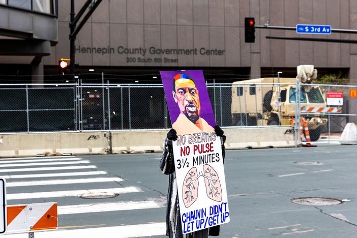 A lone protester stands outside the Hennepin County Courthouse on Monday as lawyers presented closing arguments in the murder trial of Derek Chauvin. The jury is now deliberating.