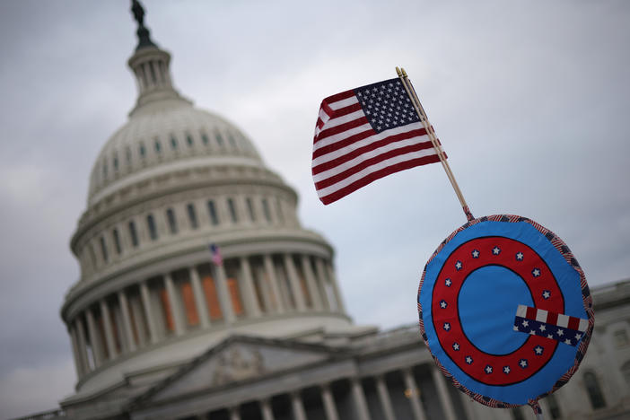 Supporters of then-President Donald Trump fly a U.S. flag with a symbol from the QAnon conspiracy theory as they gather outside the Capitol on Jan. 6 ahead of the insurrection.