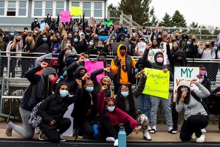 Students pose for photos during a walkout at Tartan High School in Oakdale, Minn.