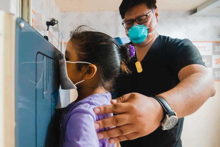 A young girl waits as her chest X-ray is taken in a TB Móvil van clinic in Lima, Peru.