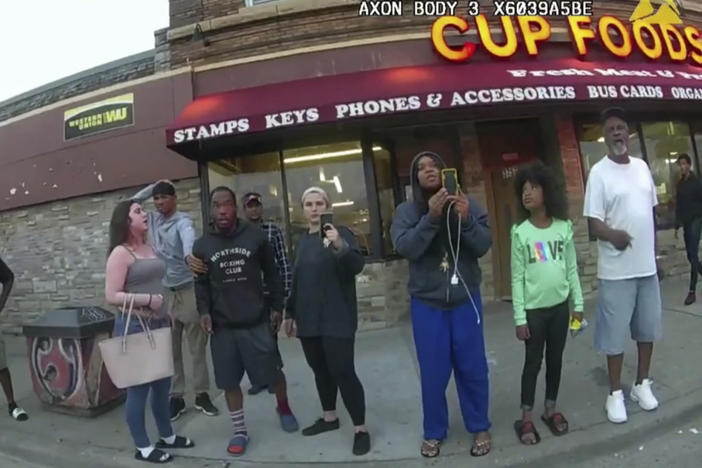 An image from a police body camera shows bystanders outside Cup Foods in Minneapolis on May 25, 2020. The group includes Darnella Frazier, third from right, as she made a 10-minute recording of George Floyd's death.
