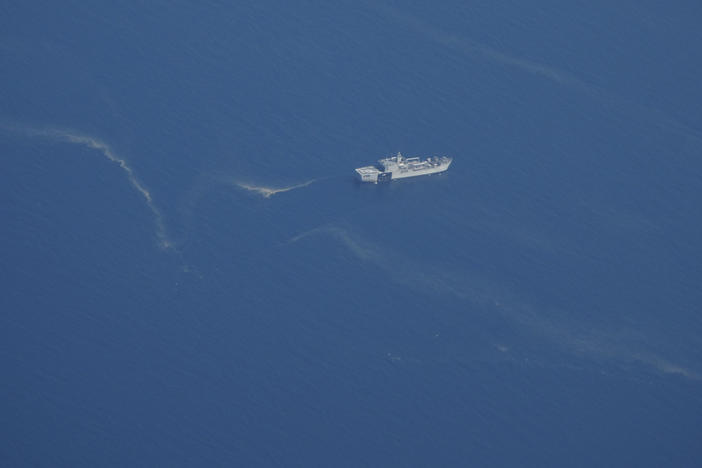 An Indonesian navy ship works near what appears to be oil slicks during a search Friday for the submarine KRI Nanggala 402 in the Bali Sea.
