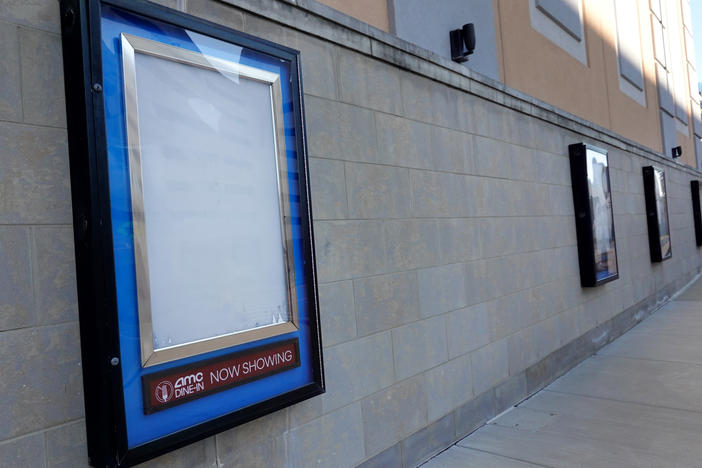 Empty frames that would normally hold movie posters hang on the front of an AMC theater shuttered by the coronavirus pandemic on Dec. 4, 2020, in Rosemont, Ill.