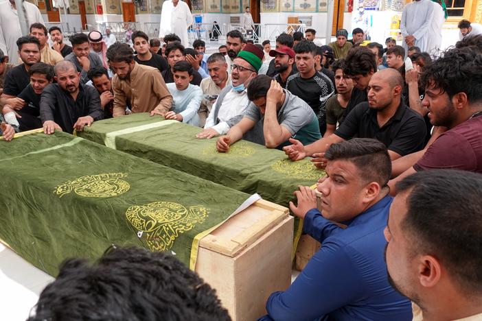 Iraqis in the holy shrine city of Najaf on Sunday mourn relatives killed during a massive fire at a Baghdad hospital dedicated to COVID-19 patients.