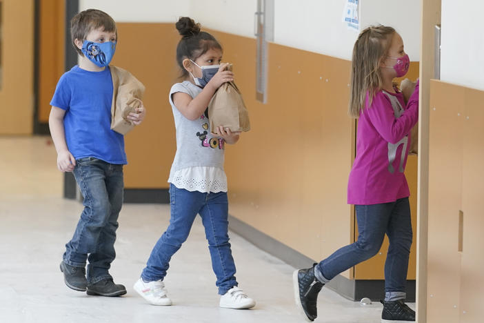 Students carry sack lunches at Elk Ridge Elementary School in Buckley, Wash. On Monday, USDA unveiled a new program that would feed millions of children over the summer, when many schools are closed.