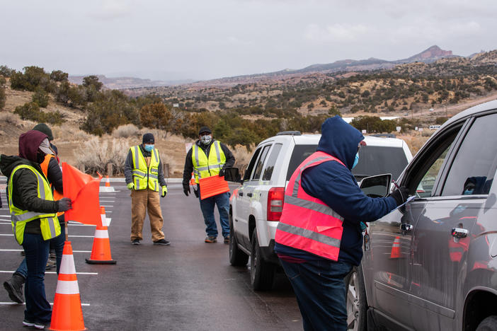 Workers greet arrivals at a drive-in vaccination site at University of New Mexico's Gallup campus in Gallup, N.M., on March 23. The Navajo Nation has vaccinated more than half of its adult population, outpacing the U.S. national rate.