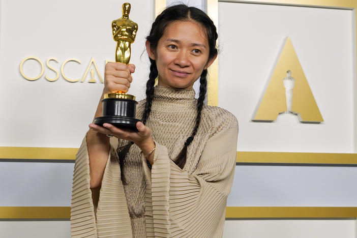 <a href="https://www.npr.org/sections/live-updates-oscars-2021/2021/04/25/988816124/chloe-zhao-is-the-first-woman-of-color-to-win-oscar-for-best-director">Chloé Zhao</a> poses in the press room at the Oscars on April 25, 2021, at Union Station in Los Angeles.