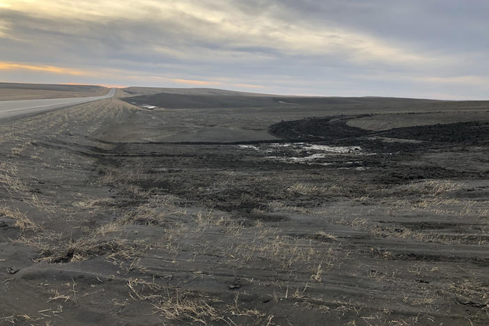 Wind-blown soil fills a ditch between a road and the fields of Gunsmoke Farms, a large organic farm northwest of Pierre, S.D., in early March.