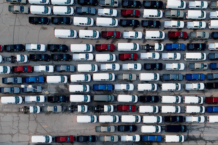 In this aerial photo, pickup trucks and vans are seen last month in a parking lot outside a General Motors assembly plant where they are produced in Wentzville, Mo. A key component in the car industry is in short supply: computer chips. Taiwan's chipmakers are racing to meet demand.