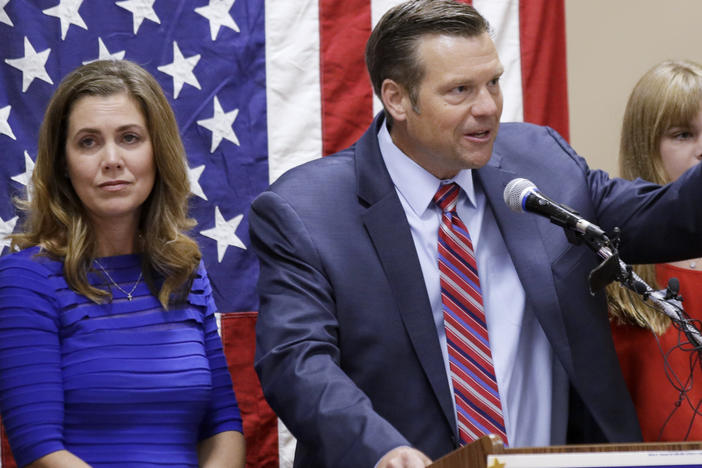 Kris Kobach, right, seen here conceding the Republican primary for U.S. Senate on Aug. 4, 2020 in Leavenworth, Kan. His wife, Heather Kobach, is to his left. Thursday he announced his run for the office of Kansas attorney general.