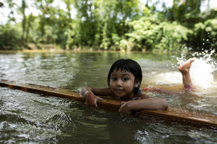 A child learns to swim in a pond in a rural area of Bangladesh.