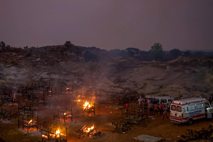 Funeral pyres burn in a disused granite quarry repurposed to cremate the dead due to COVID-19 on Friday in Bengaluru, India. The U.S. is set to impose new travel restrictions against travelers from the country.