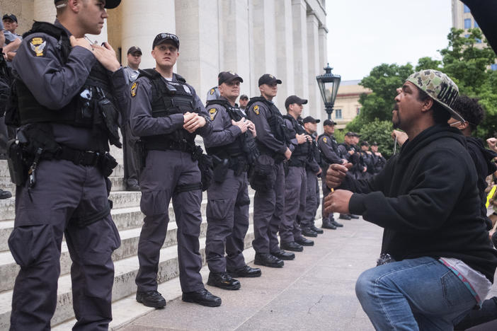 Protesters chant for Ohio state troopers and Columbus police to take a knee with them in solidarity on the Ohio Statehouse steps on June 1, 2020, in Columbus. A federal judge has ordered Columbus police to stop using force against nonviolent protesters.