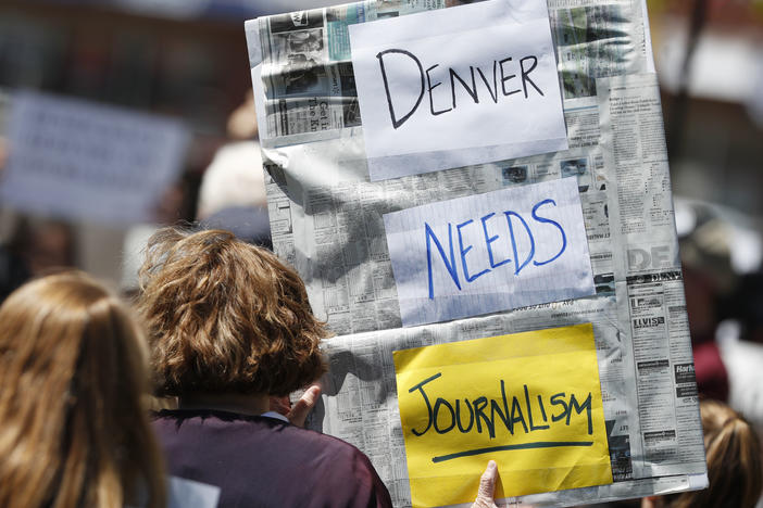 A sign from a rally against the ownership of the <em>Denver Post</em>, Alden Global Capital, in May 2018. Former <em>Post </em>journalists created <em>The Colorado Sun</em> that year; now <em>The Sun</em> has acquired two dozen suburban Denver papers.