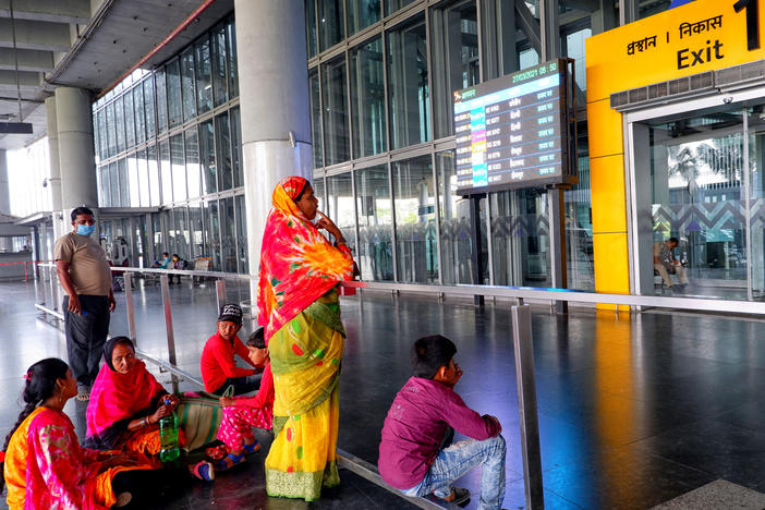 People wait at an exit gate at the Kolkata Airport Terminal. International air travel to and from India has been restricted as the country battles a catastrophic COVID-19 surge.