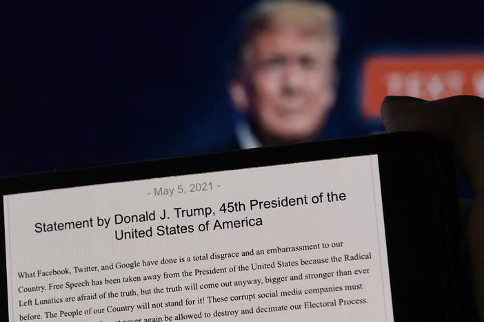 A statement from former President Donald Trump is seen in front of his Facebook page background. Facebook was justified in its decision to suspend Trump after the Jan. 6 insurrection, the company's Oversight Board said Wednesday.