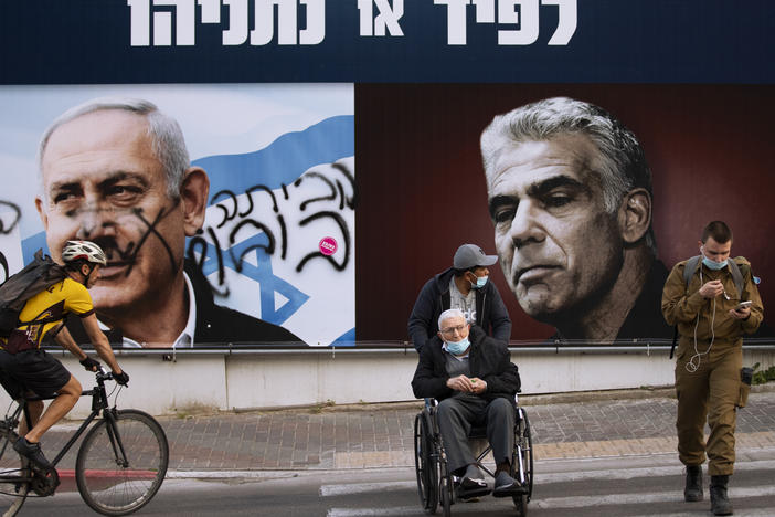 An election campaign billboard for the Likud party shows its leader, Prime Minister Benjamin Netanyahu (left), and opposition party leader Yair Lapid, in Ramat Gan, Israel, days before that country's election in March. The banner reads "Lapid or Netanyahu." Spray paint on Netanyahu's portrait reads, "Go home."