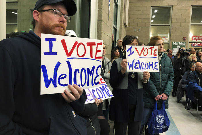 In this Dec. 9. 2019, file photo, residents in support of continued refugee resettlement hold signs at a meeting in Bismarck, N.D.