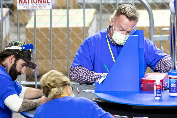Contractors working for the firm Cyber Ninjas, which was hired by the Republican-led Arizona state Senate, count Maricopa County ballots from the 2020 general election at Veterans Memorial Coliseum on Saturday in Phoenix.