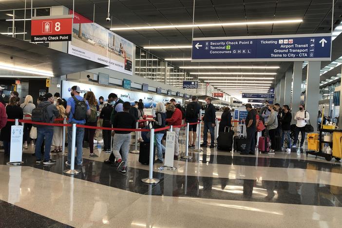 A line loops through security at Chicago's O'Hare International Airport as travelers return to the skies after mostly staying home during the coronavirus pandemic.