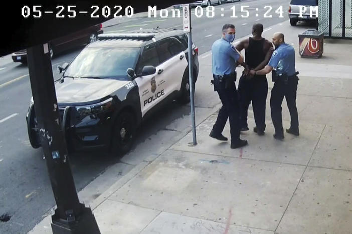 This image from video shows Minneapolis police officers Thomas Lane, left, and J. Alexander Kueng, right, escorting George Floyd, center, to a police vehicle outside Cup Foods in Minneapolis, on May 25, 2020. The image was shown as prosecutor Steve Schleicher gave closing arguments in the trial of Derek Chauvin for the death of Floyd.