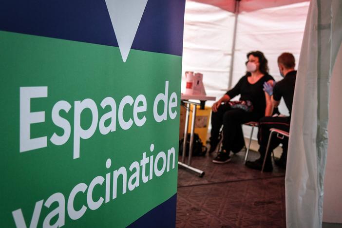 A firefighter administers the Pfizer-BioNTech COVID-19 vaccine at a vaccination center near Paris on Monday. The European Union has signed a deal to buy as many as 1.8 billion doses.