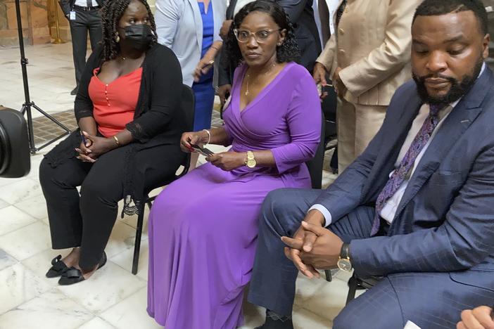 Ahmaud Arbery's relatives, including sister Jasmine Arbery (left) and his mother, Wanda Cooper-Jones (second from left), sit at the Georgia Capitol in Atlanta on Monday to witness Gov. Brian Kemp sign a law repealing the state's citizen's arrest statute.